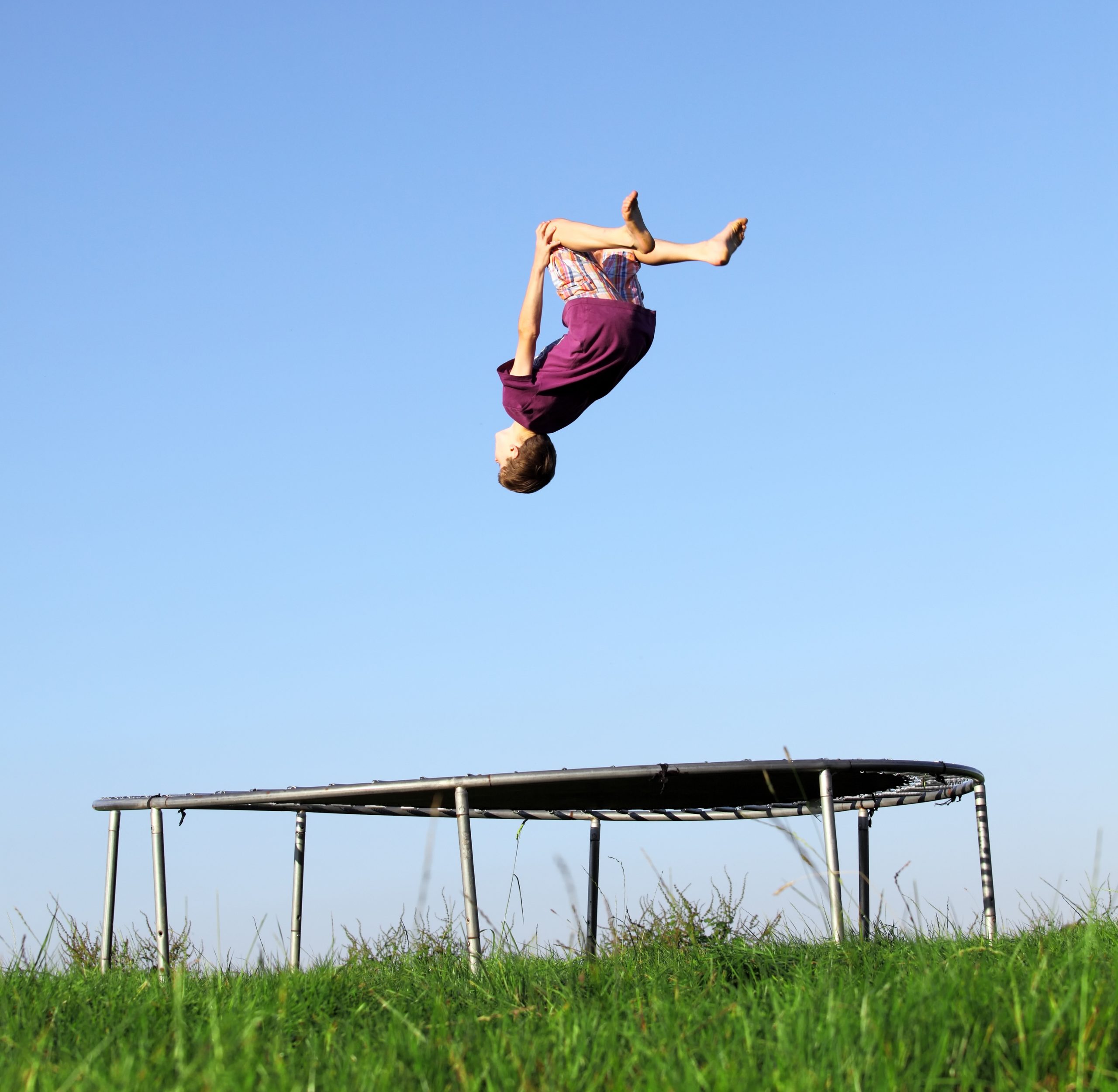 man performing a backflip on a trampoline