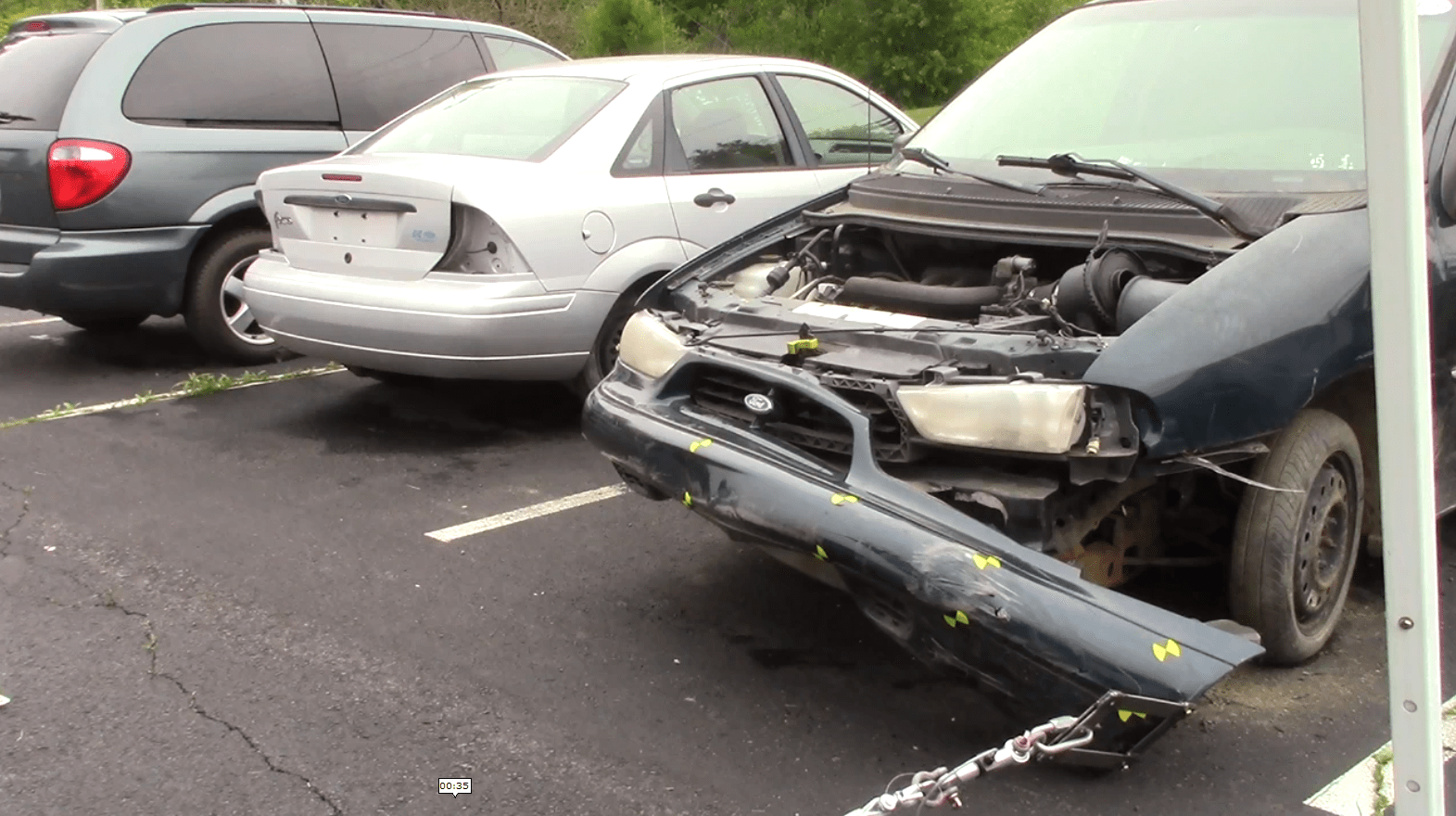three damaged automobiles in a parking lot