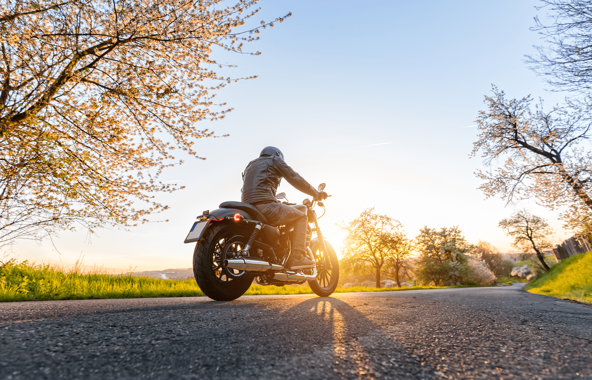 man on motorcycle riding on paved road